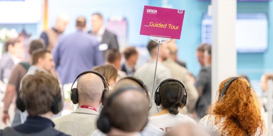 Menschen folgen einem Schild mit Guided Tours
