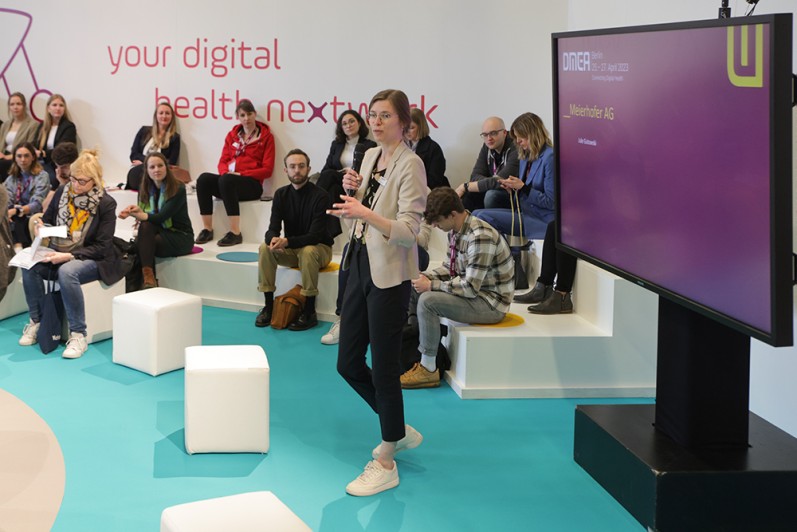 Eine Frau spricht auf der DMEA sparks-Fläche. Eine Frau spricht auf der DMEA sparks-Fläche.