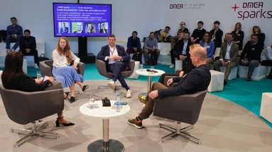 Vier Personen bei einer Panel-Diskussion, rundum sitzt Publikum.