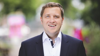 Man wears blue jacket with white shirt.