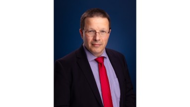 Man with dark blue jacket, purple shirt and red tie.