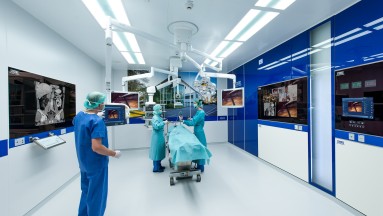 Das Bild zeigt einen Blick in einen hochmodernen OP-Saal während einer Operation.