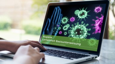 Das Bild zeigt einen Laptop. Der Bildschirm zeigt das Titelbild des E-Learning-Kurses Basisunterweisung Hygiene von Relias.