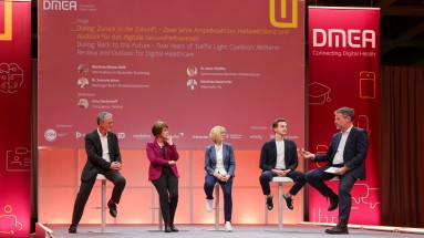 Zwei Männer und zwei Frauen unterhalten sich in einer Talkrunde auf der Bühne mit dem Moderator