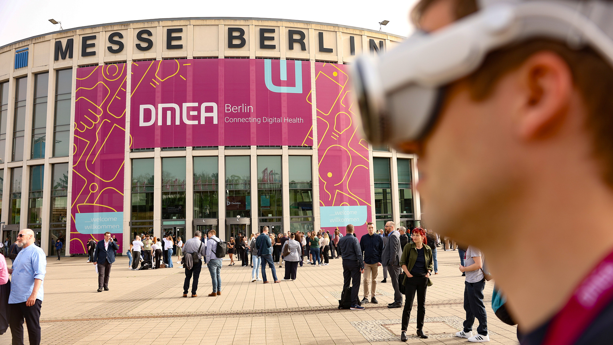 Eingang Messe Süd, im Vordergrund ein Mann mit einer VR-Brille Eingang Messe Süd, im Vordergrund ein Mann mit einer VR-Brille