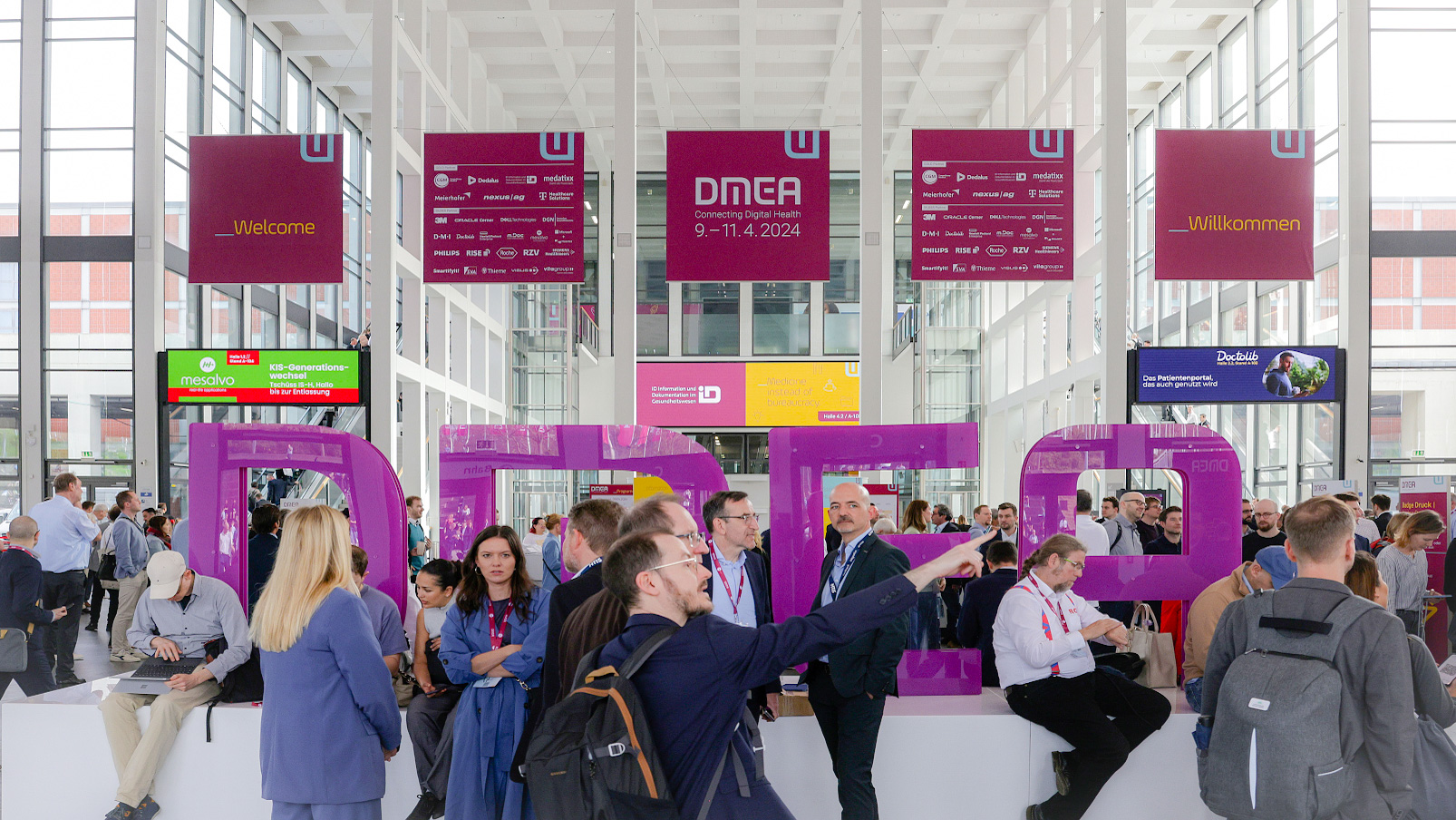 Blick in den Eingang Messe Süd der Messe Berlin mit den DMEA Buchstaben und Besucher:innen drumherum Blick in den Eingang Messe Süd der Messe Berlin mit den DMEA Buchstaben und Besucher:innen drumherum