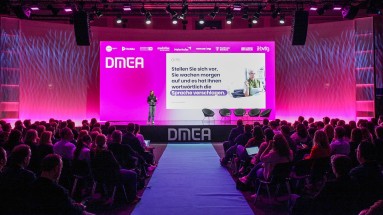 Eine Person steht auf einer Bühne der DMEA 2025 und hält eine Präsentation. Eine Person steht auf einer Bühne der DMEA 2025 und hält eine Präsentation.